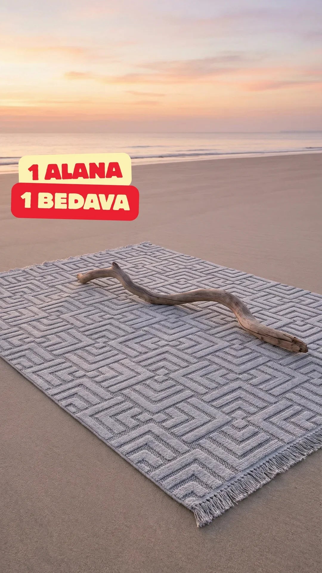 Plajda desenli gri halı ve üzerinde doğal dal parçası, gün batımı gökyüzü
