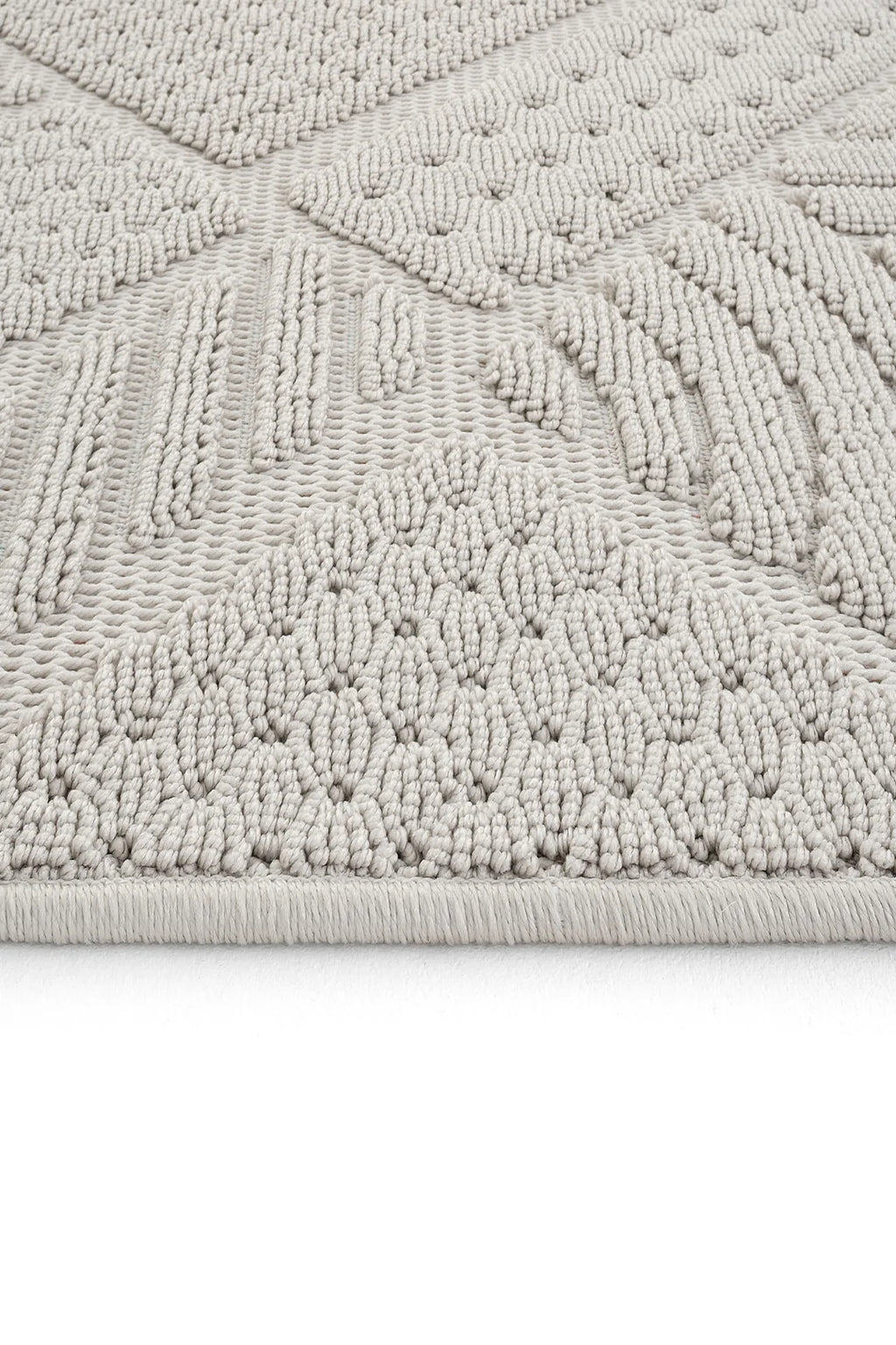 Krem renkli kabartmalı geometrik desenli yumuşak dokulu halı köşe detayı