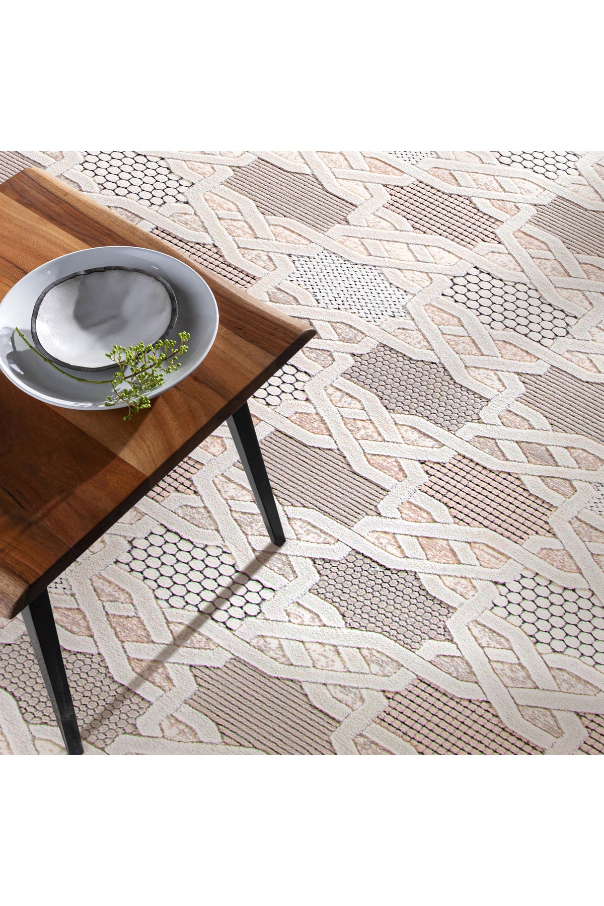 Ahşap sehpa üzerinde beyaz ve siyah desenli tabaklarla modern geometrik desenli halı