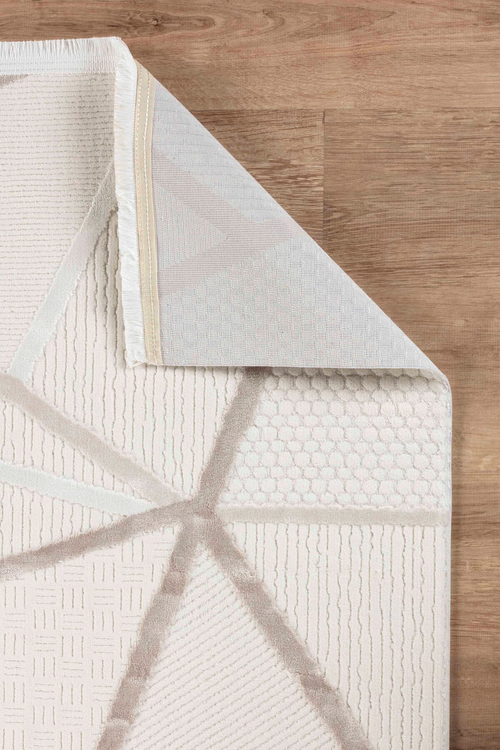 Bej ve krem renkli geometrik desenli lüks dekoratif halı ve ahşap zemin