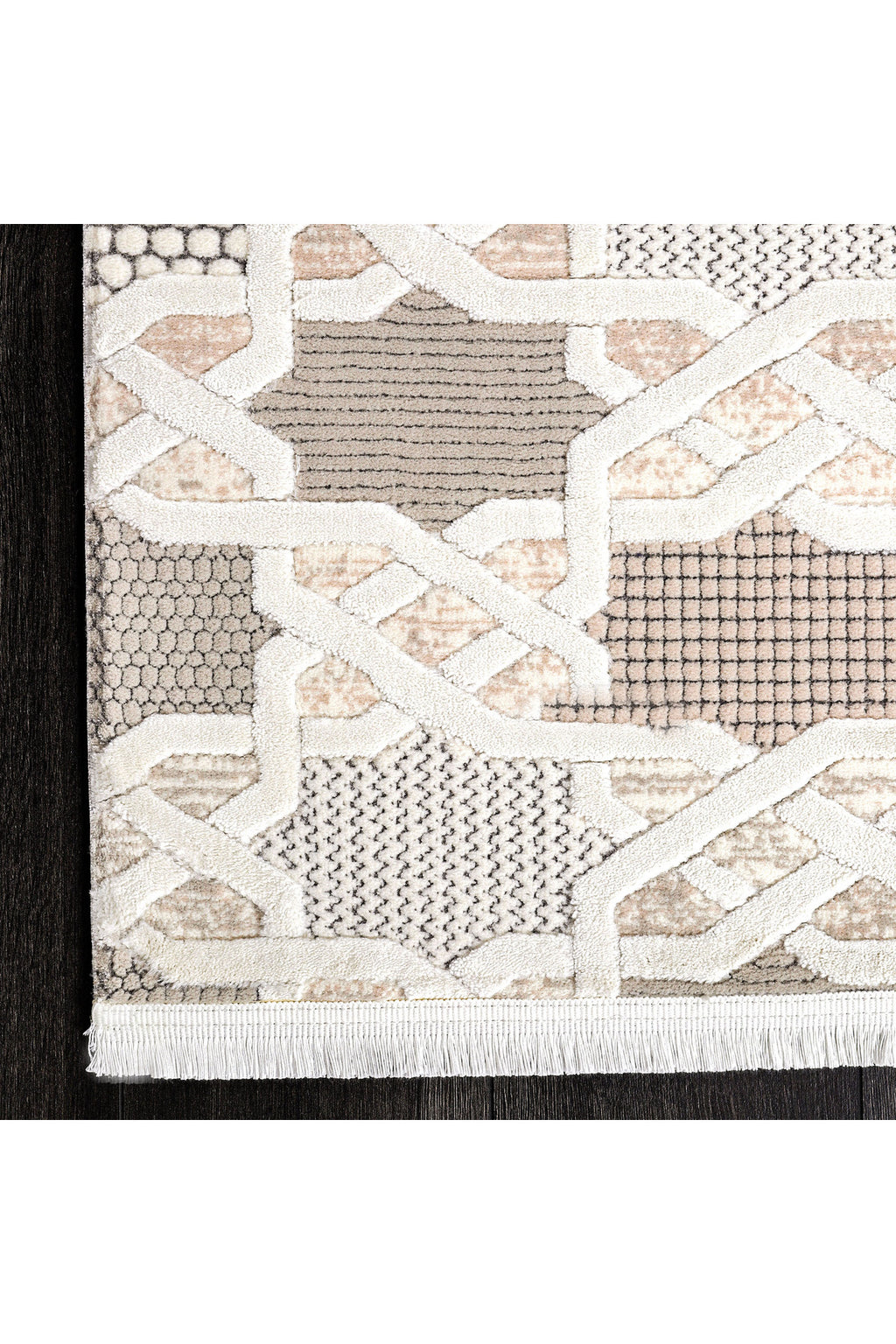 Açık pembe, bej ve gri tonlarında geometrik desenli modern halı köşesi, koyu ahşap zemin üzerinde