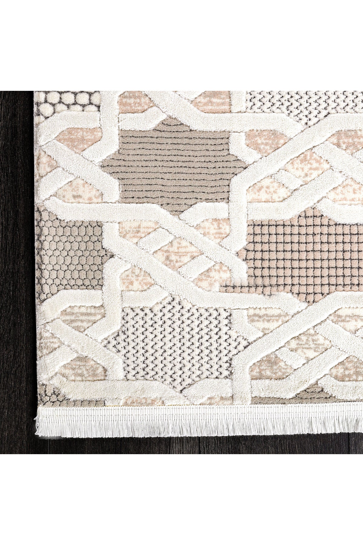 Açık pembe, bej ve gri tonlarında geometrik desenli modern halı köşesi, koyu ahşap zemin üzerinde