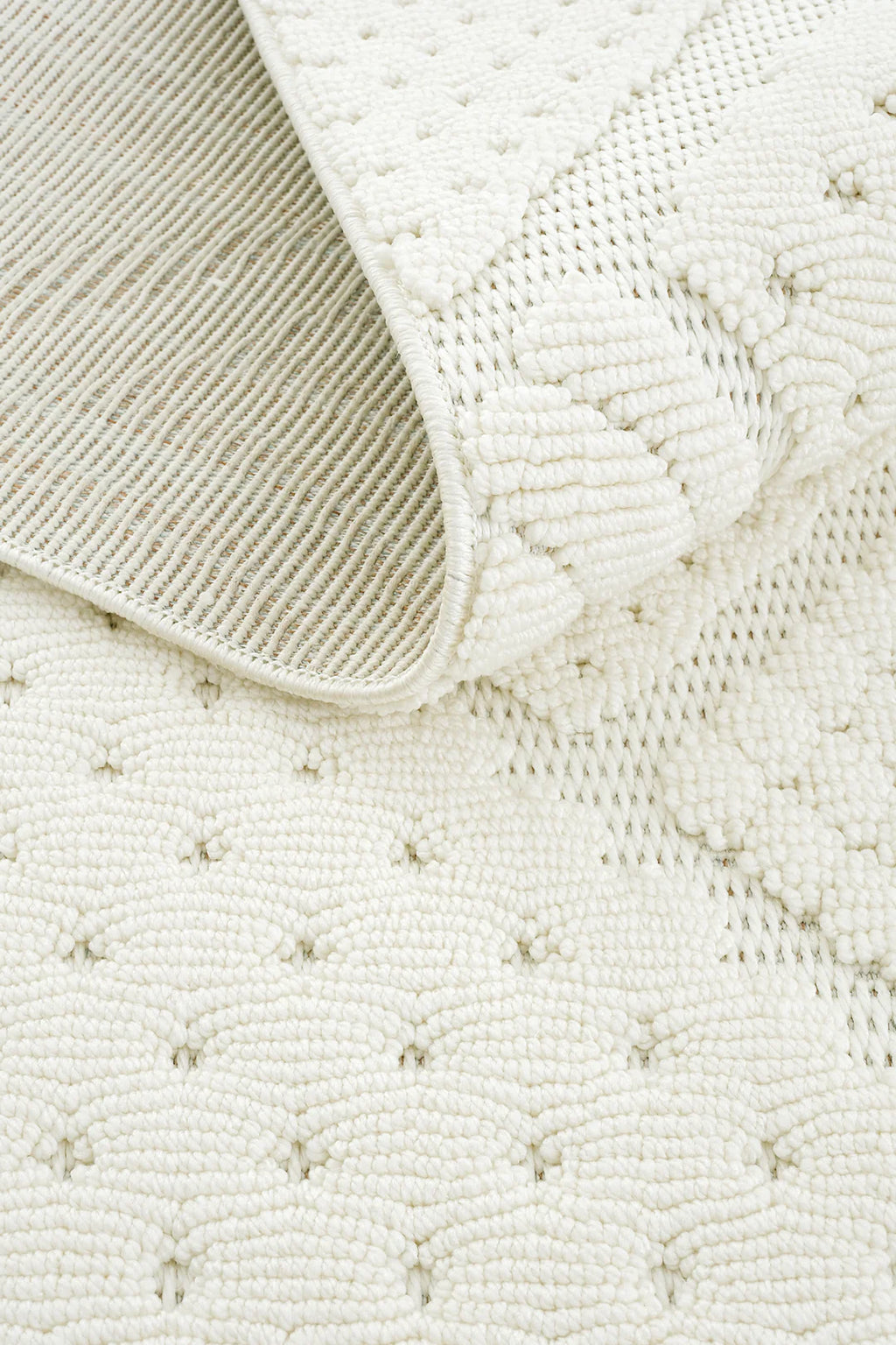 Beyaz dokuma desenli, kaymaz alt yüzeye sahip dekoratif halı close-up görüntüsü