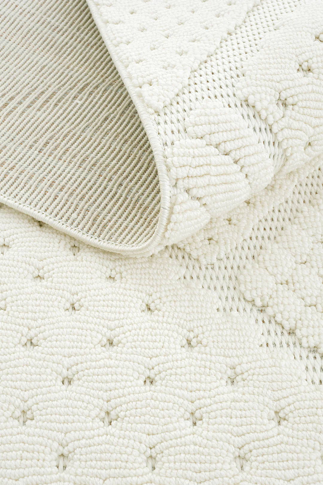 Beyaz dokuma desenli, kaymaz alt yüzeye sahip dekoratif halı close-up görüntüsü