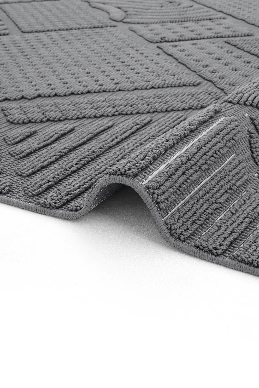 Gri renkli dokulu yumuşak banyo paspası, detaylı kabartmalı desenli ve kıvrılmış köşeli