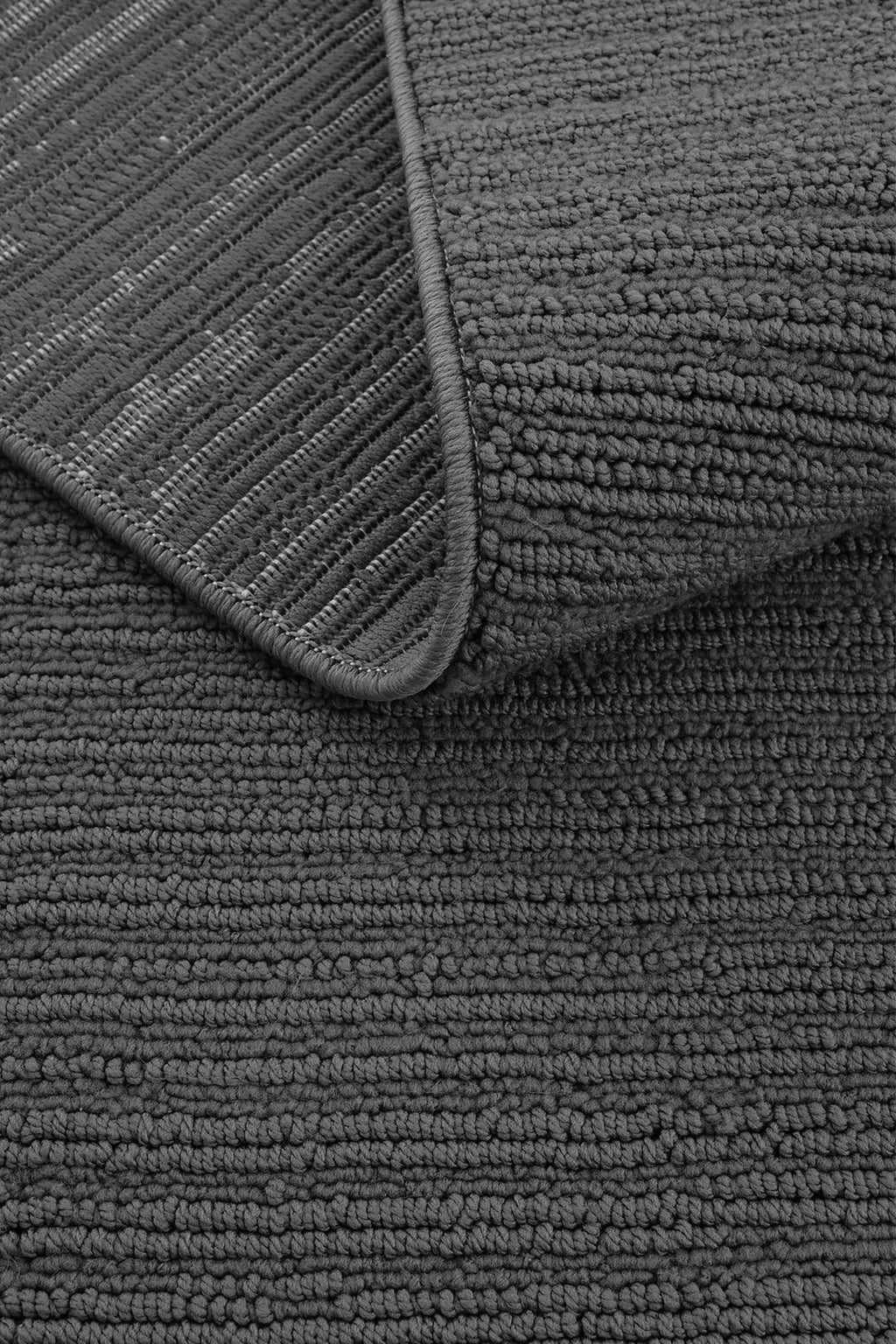 Koyu gri renkte dokulu, kıvrılmış banyo paspası detay görüntüsü