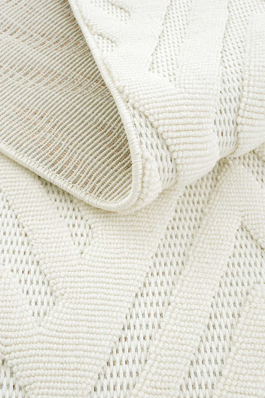 Beyaz kabartmalı geometrik desenli yumuşak dokulu dekoratif halı detay görüntüsü