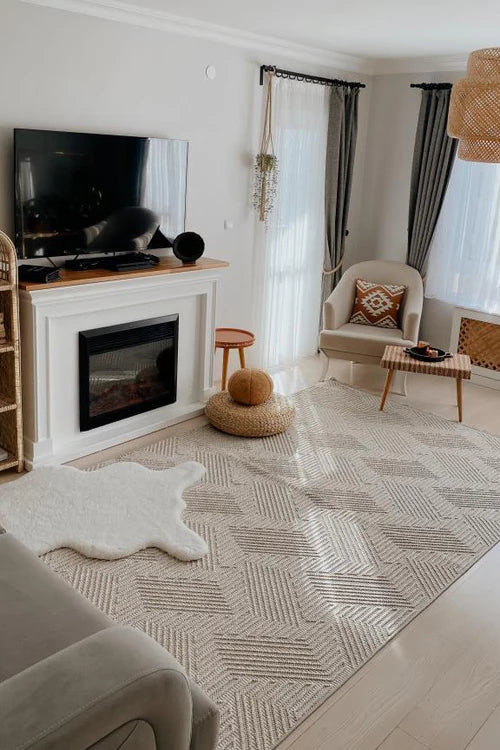 Modern oturma odası, beyaz elektrikli şömine, duvara monte TV, açık krem tonlarında halı ve rahat sandalye