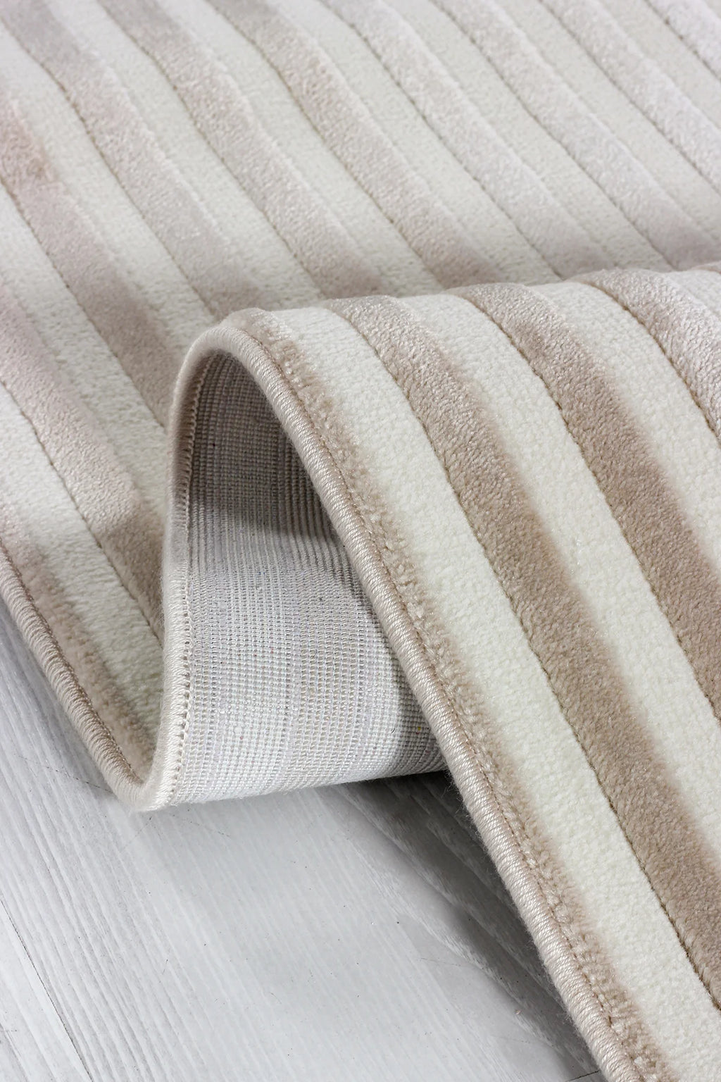 Krem ve bej renkli çizgili yumuşak dokulu makine halısı detay fotoğrafı