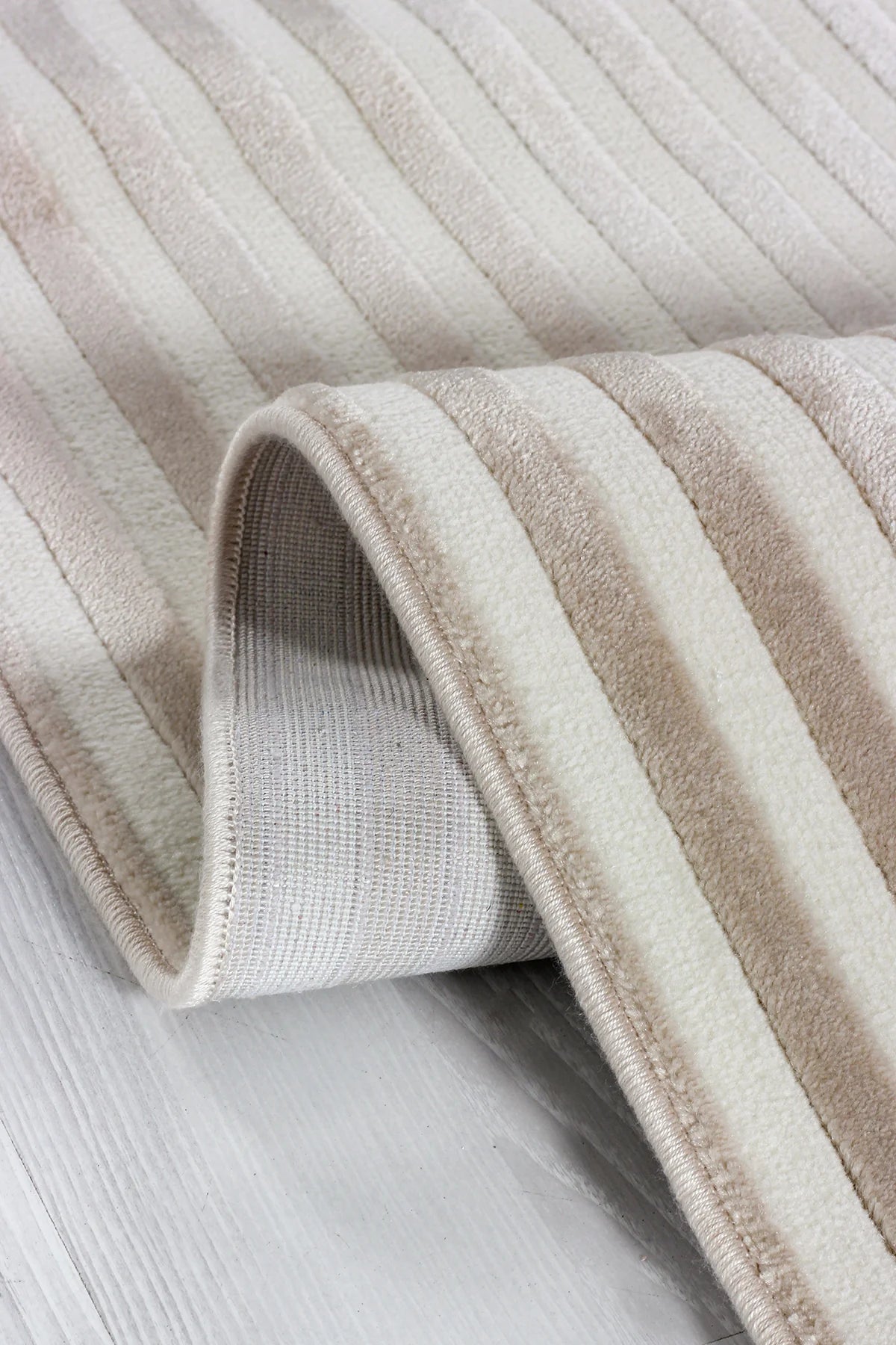 Krem ve bej renkli çizgili yumuşak dokulu makine halısı detay fotoğrafı