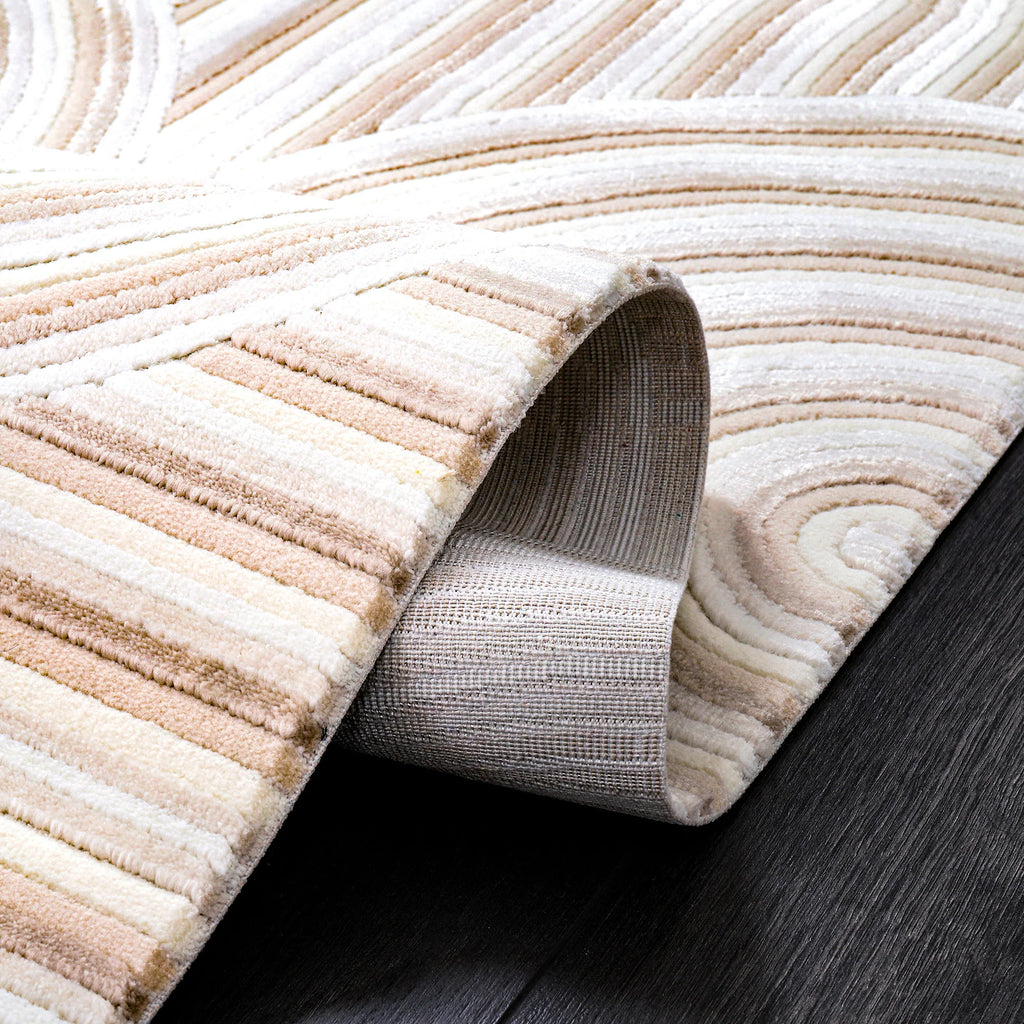 Krem ve kahve tonlarında yumuşak dokulu, makine halısı, kıvrılmış halde koyu zemin üzerinde