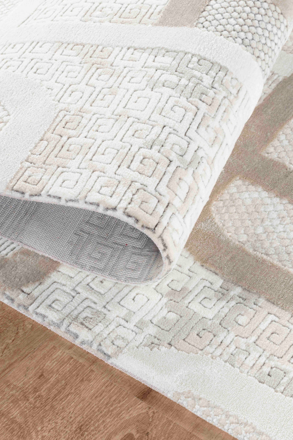 Bej ve krem renklerde, yumuşak dokulu, geometrik desenli makine halısı detay görüntüsü