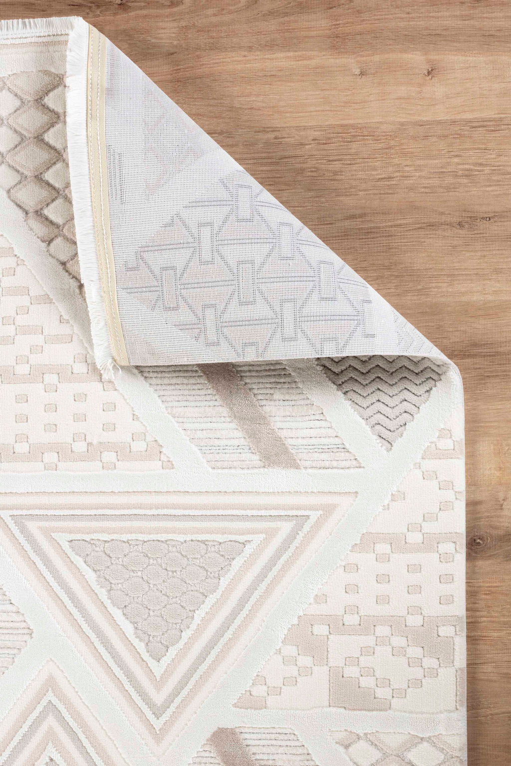 Krem kahve renklerde geometrik desenli yumuşak dokulu makine halısı, ahşap zeminde