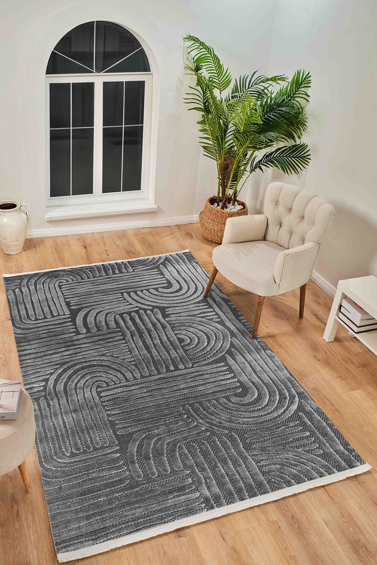 Gri geometrik desenli yumuşak dokulu salon halısı, krem berjer, büyük yeşil bitki ve beyaz pencere