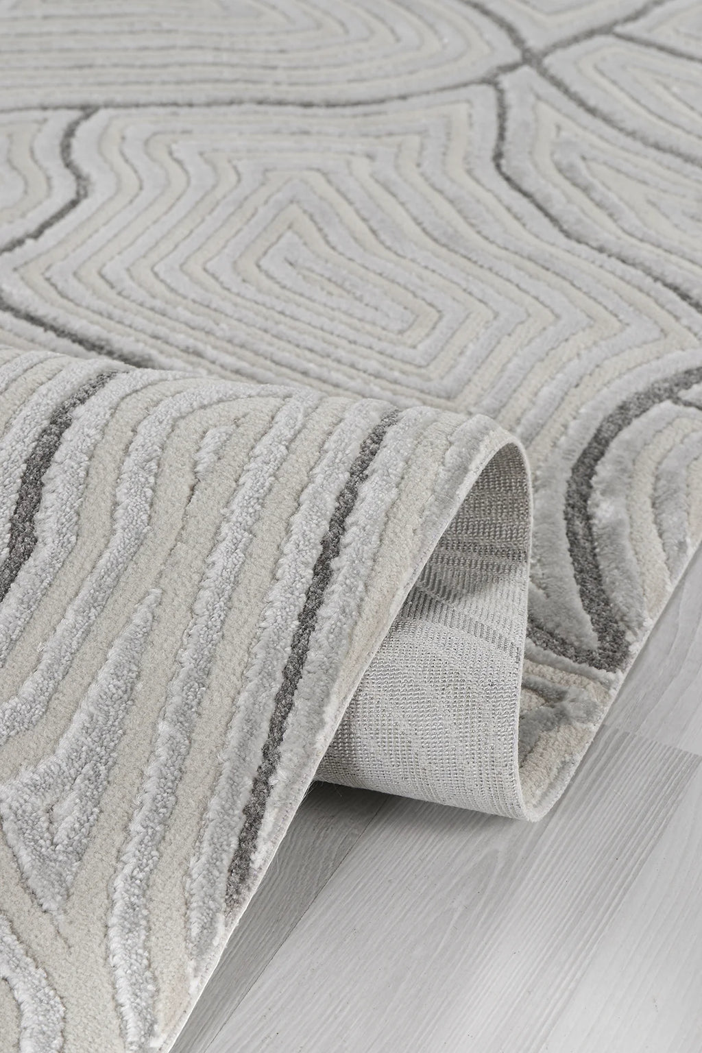 Gri tonlarda kabartmalı geometrik desenli yumuşak dokulu modern halı