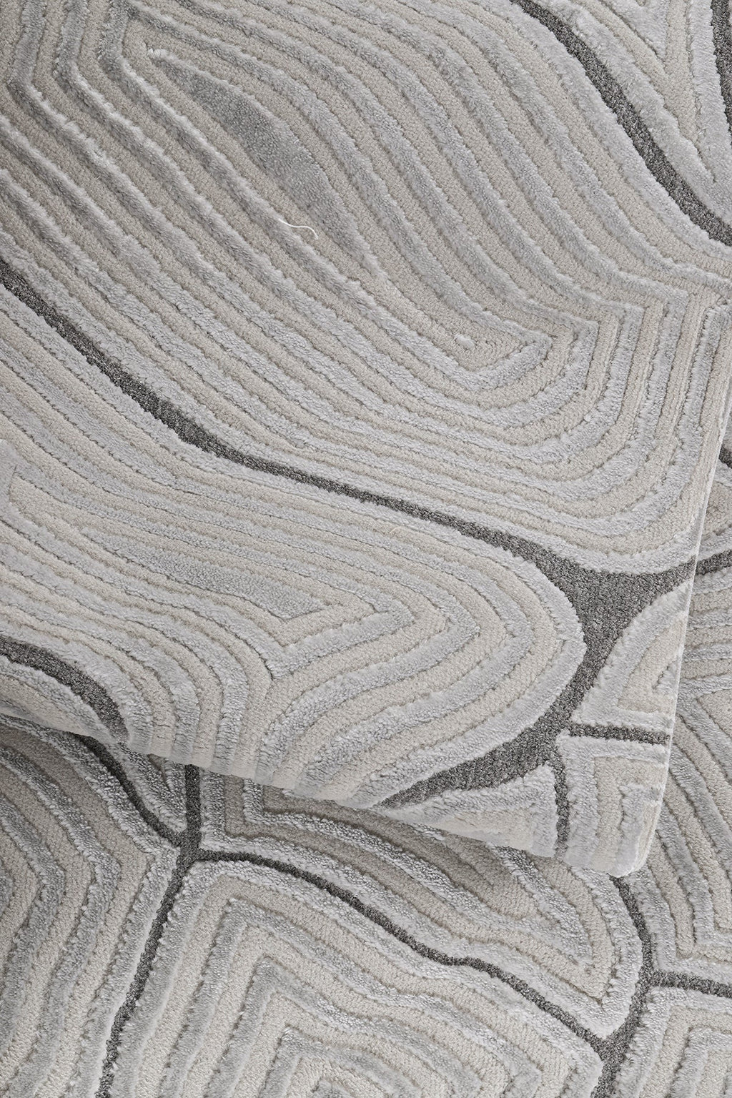 Gri ve bej tonlarında soyut desenli yumuşak dokulu makine halısı