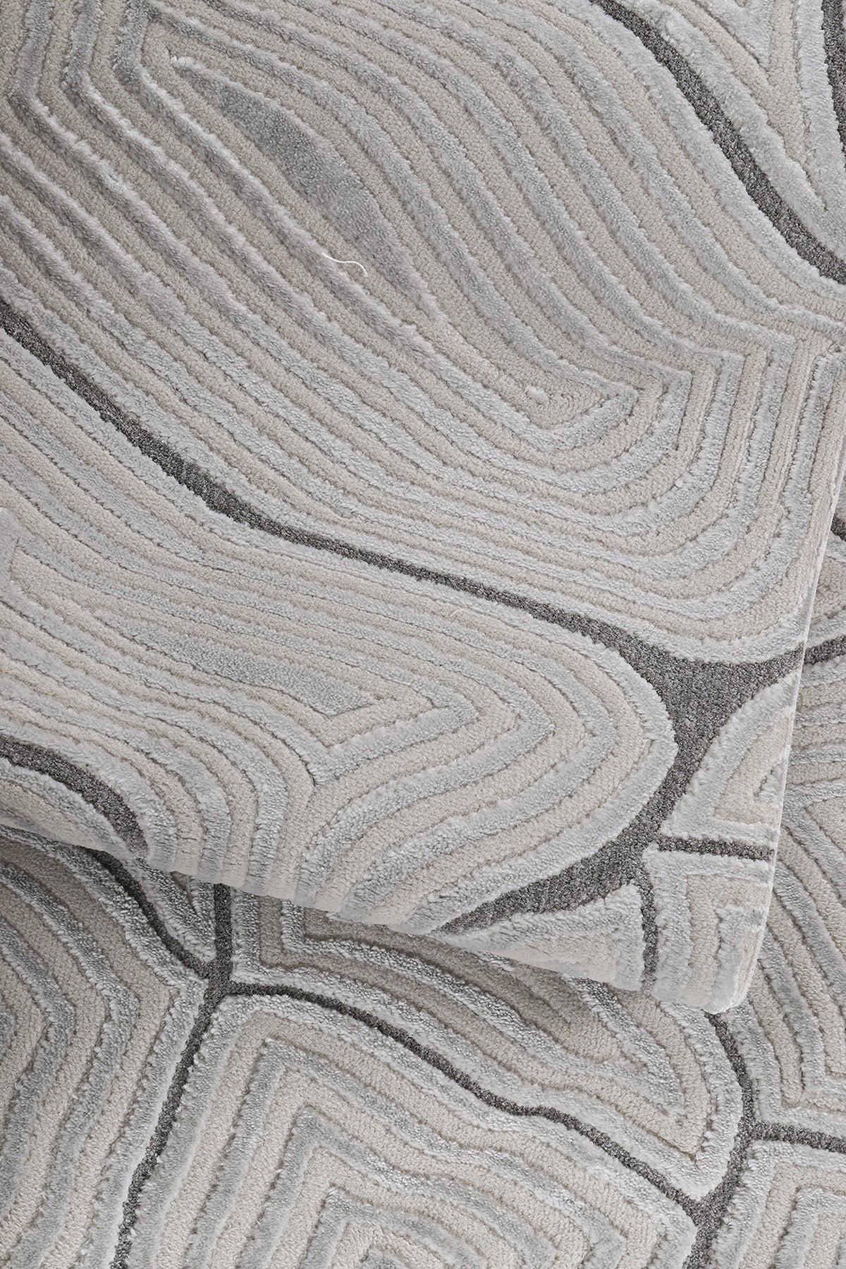 Gri ve bej tonlarında soyut desenli yumuşak dokulu makine halısı