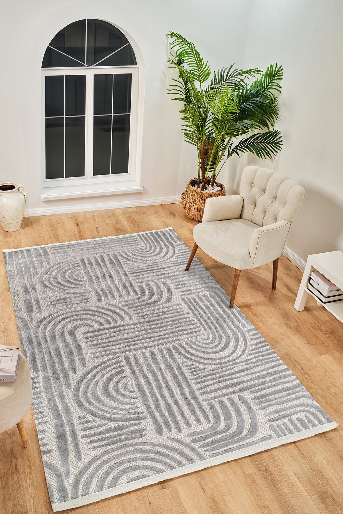 Gri geometrik desenli modern yumuşak dokulu halı, bej koltuk ve doğal bitki ile oturma odası