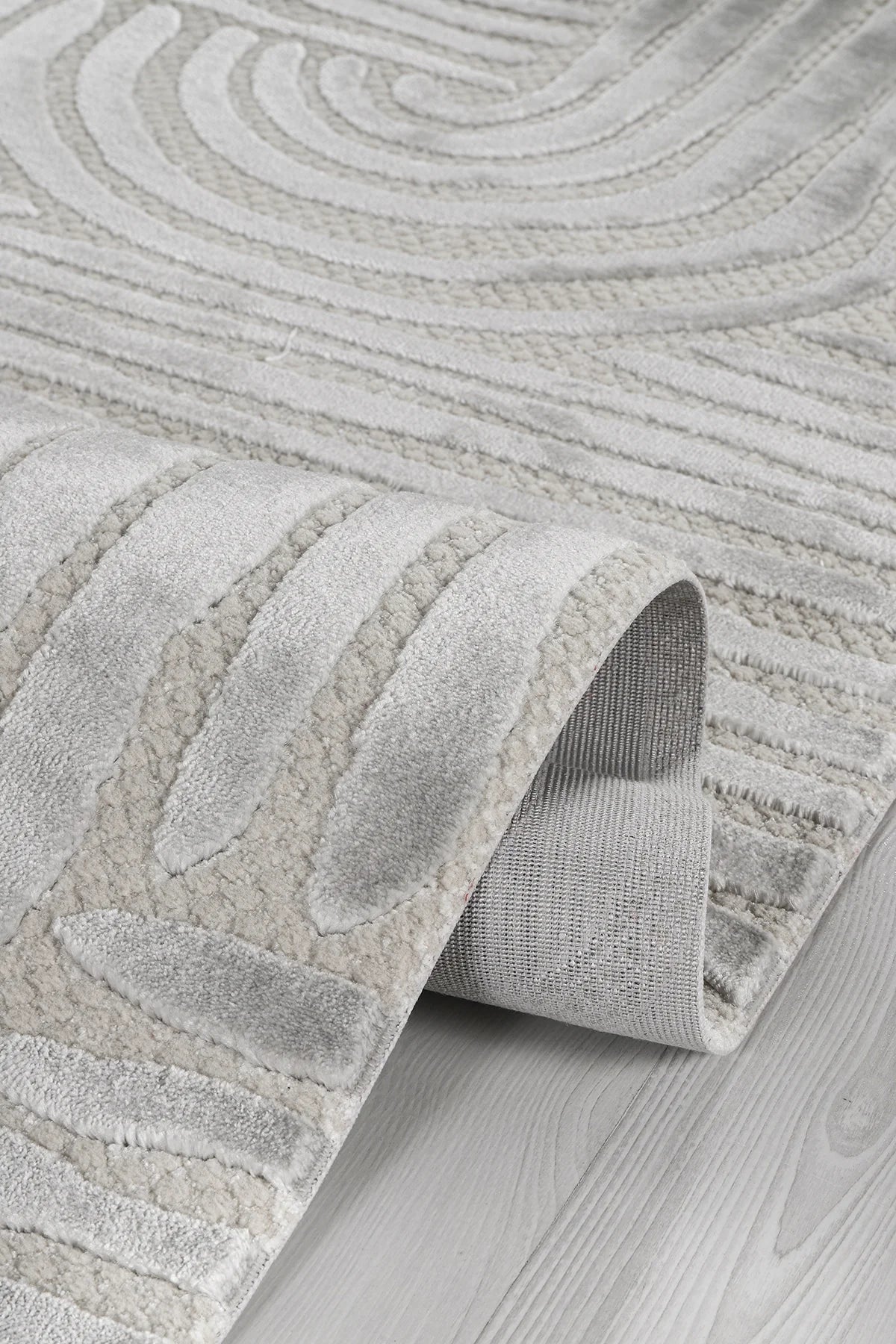 Açık gri tonlarında kabartmalı geometrik desenli yumuşak dokulu salon halısı