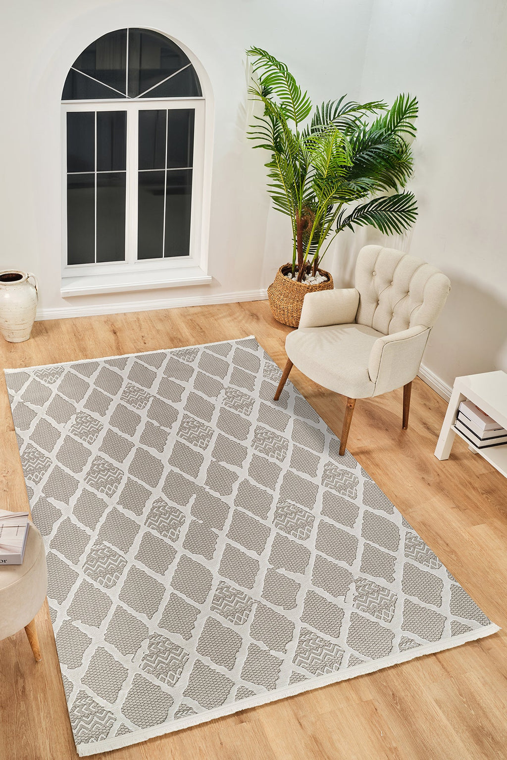 Modern krem bej desenli yumuşak dokulu halı, açık krem koltuk ve bitkiyle şık salon dekoru