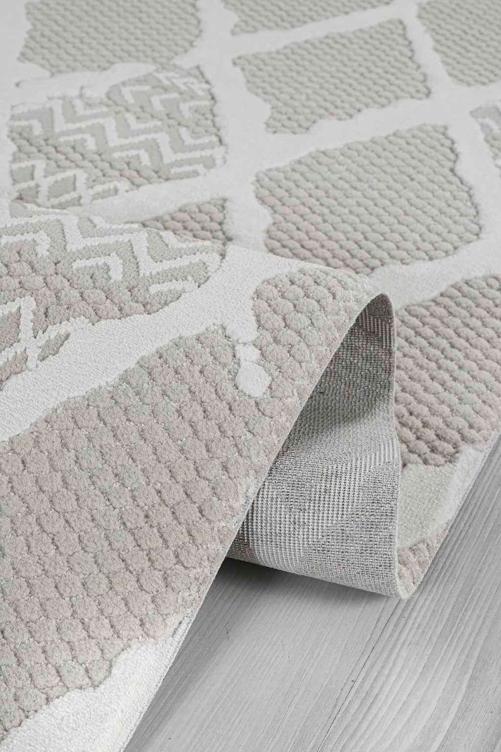 Gri ve beyaz geometrik desenli yumuşak dokulu makine halısı detay fotoğrafı
