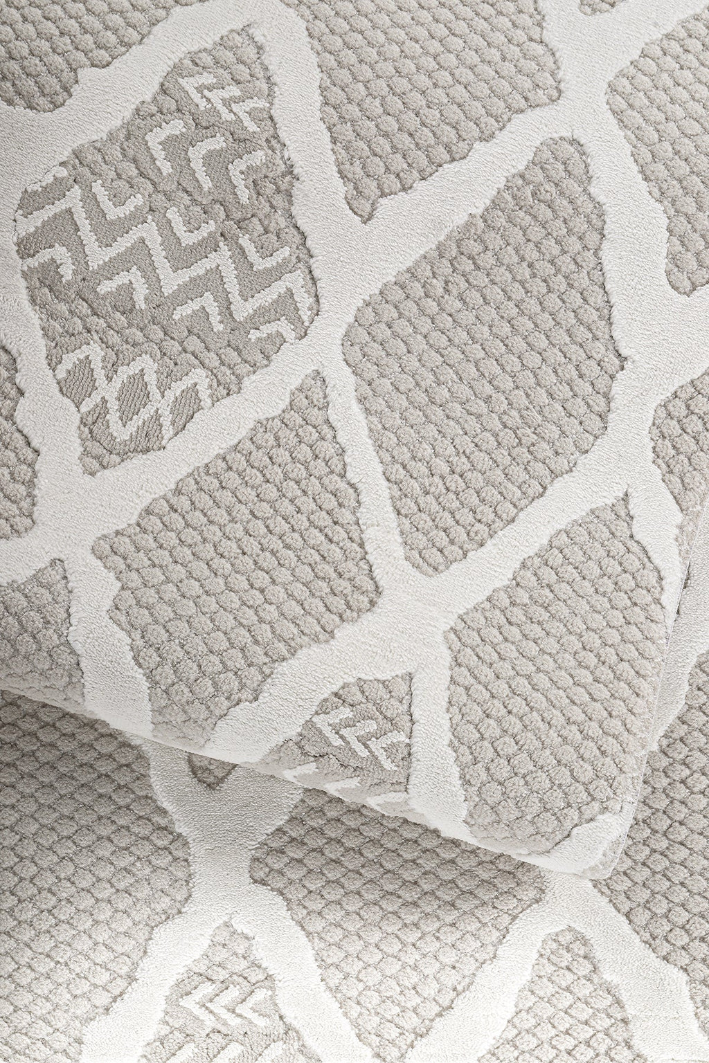 Bej ve beyaz geometrik desenli yumuşak dokulu makine halısı detay görüntüsü