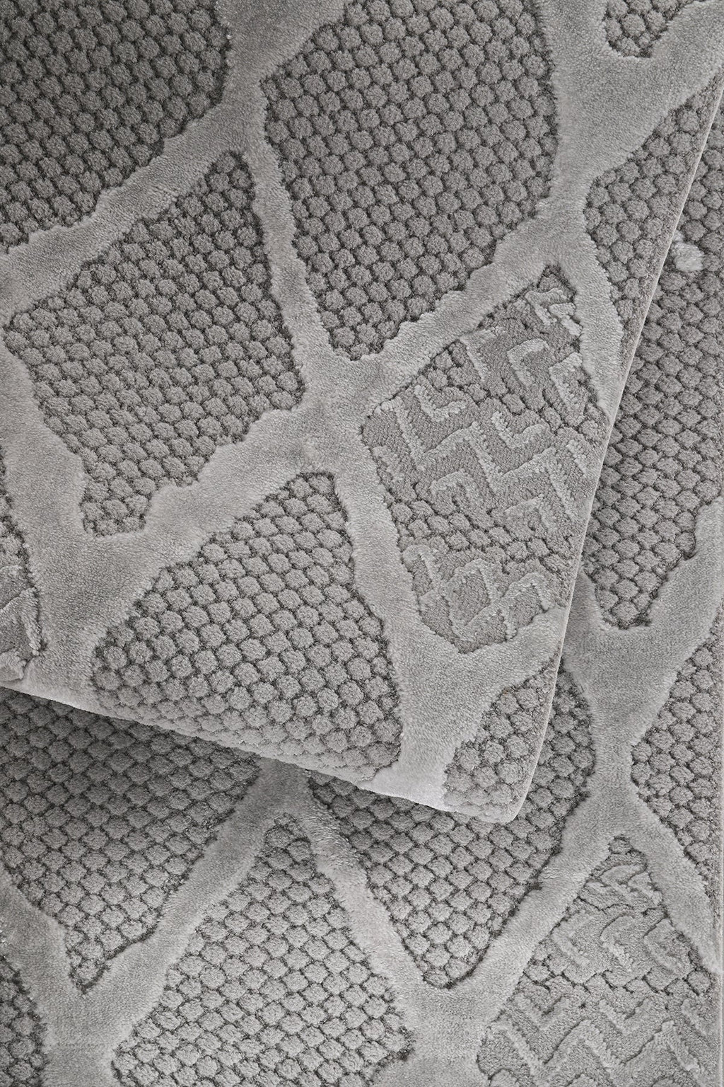 Gri renkli, yumuşak dokulu, desenli modern makine halısı yakından görünüm