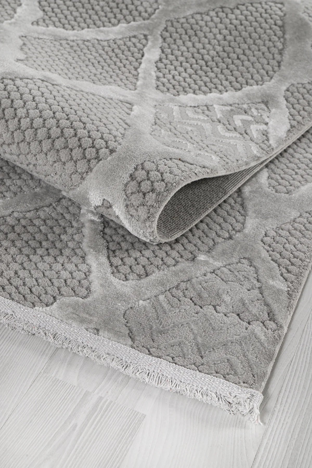 Gri renkli yumuşak dokulu, desenli makine halısı, açık renk ahşap zeminde