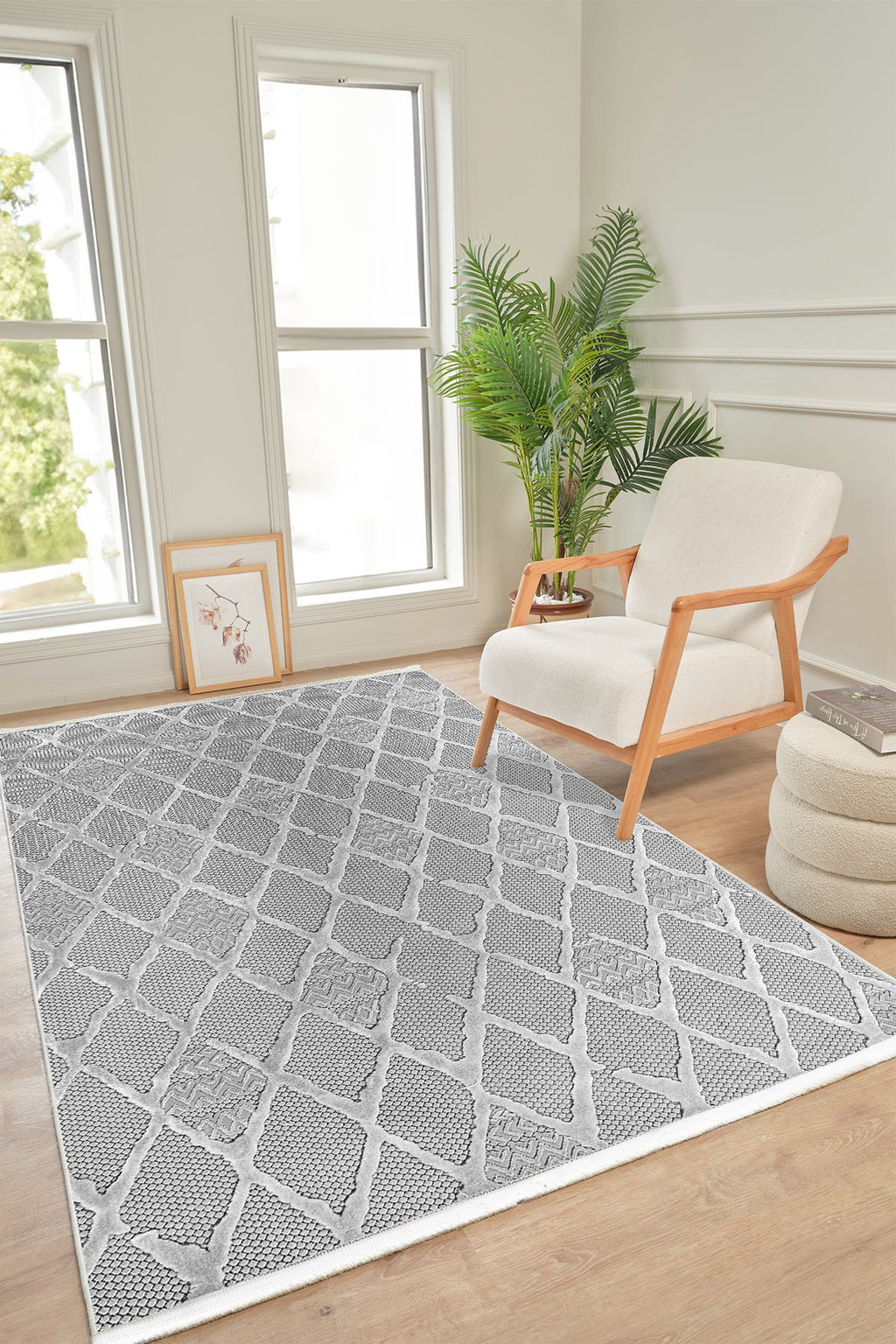 Gri desenli halı, beyaz sandalye, saksıda yapay bitki ve açık pencere ile modern salon köşesi