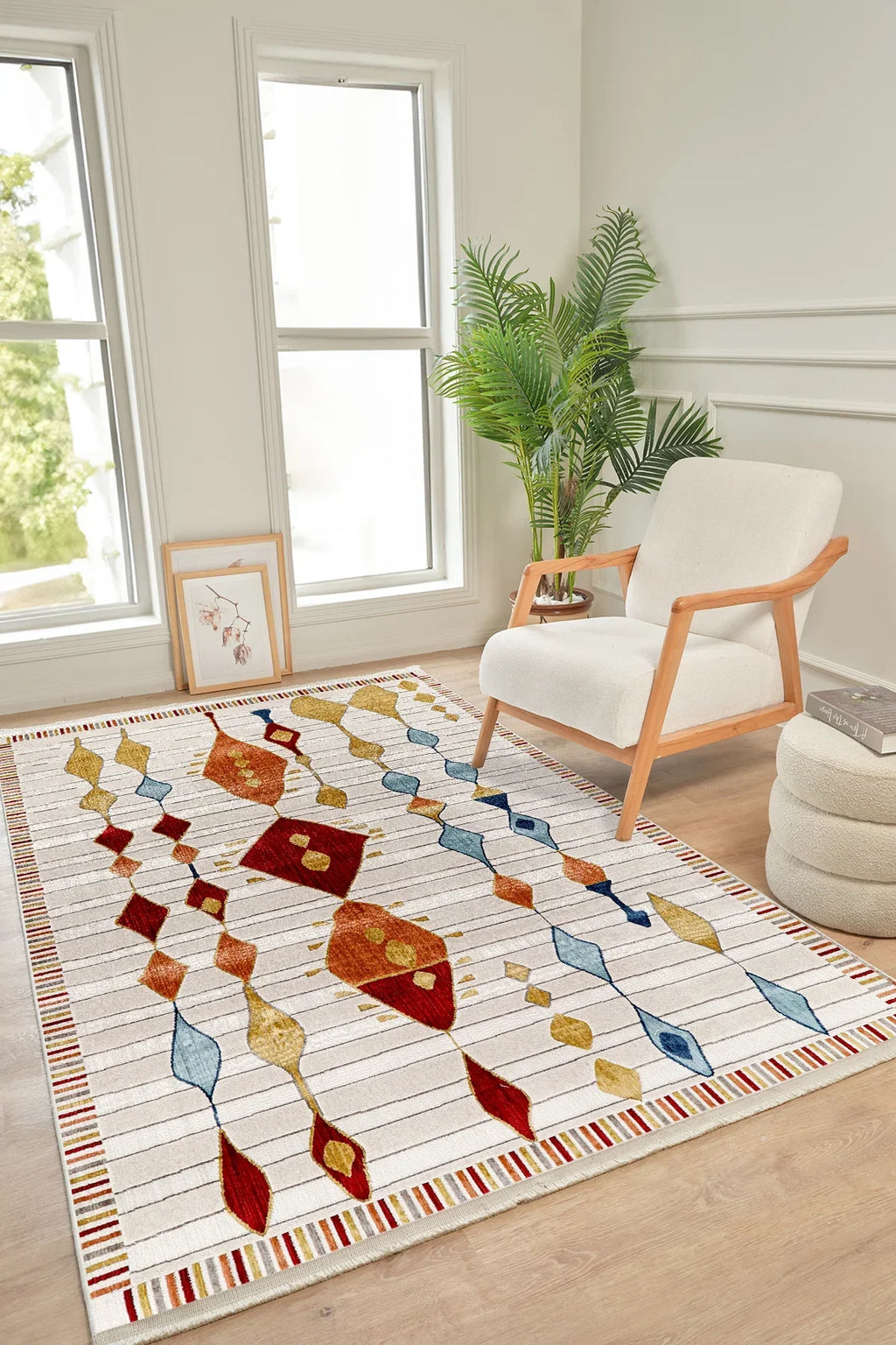 Renkli geometrik desenli salon halısı, beyaz koltuk, bitki ve açık aydınlık iç mekan