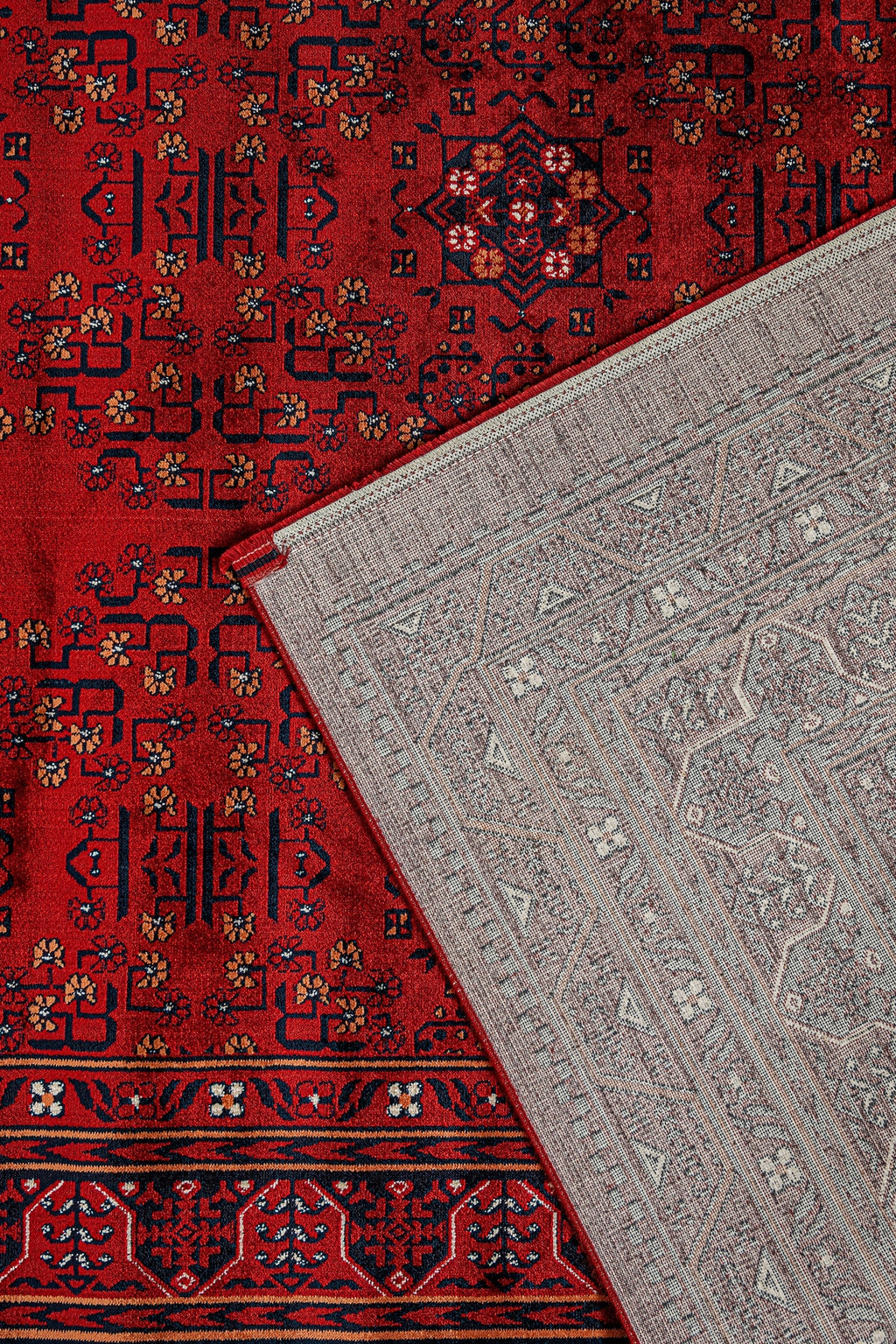 Kırmızı Afgan halısı ve üstünde ters çevrilmiş açık gri desenli dekoratif halı detayı