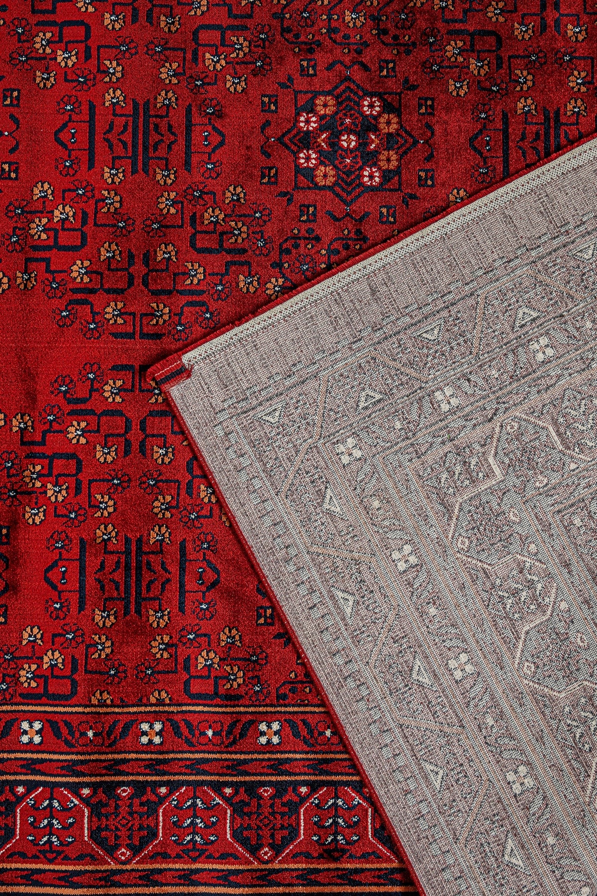 Kırmızı Afgan halısı ve üstünde ters çevrilmiş açık gri desenli dekoratif halı detayı