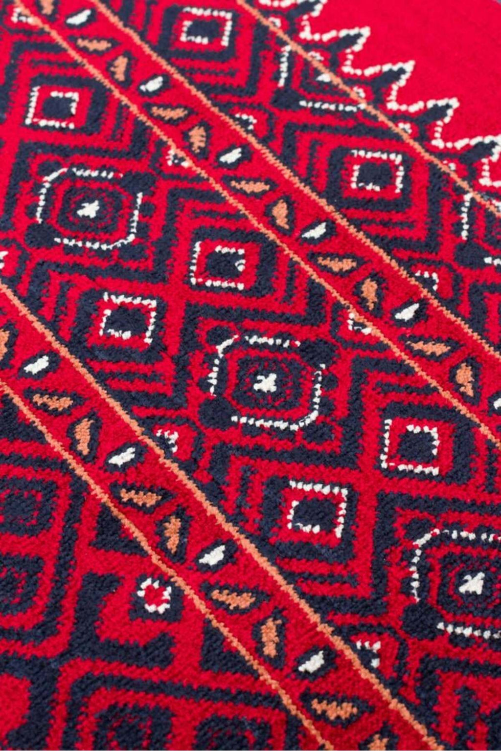 Kırmızı zemin üzerine siyah, beyaz ve kahverengi geometrik desenli Afgan halısı detay görüntüsü