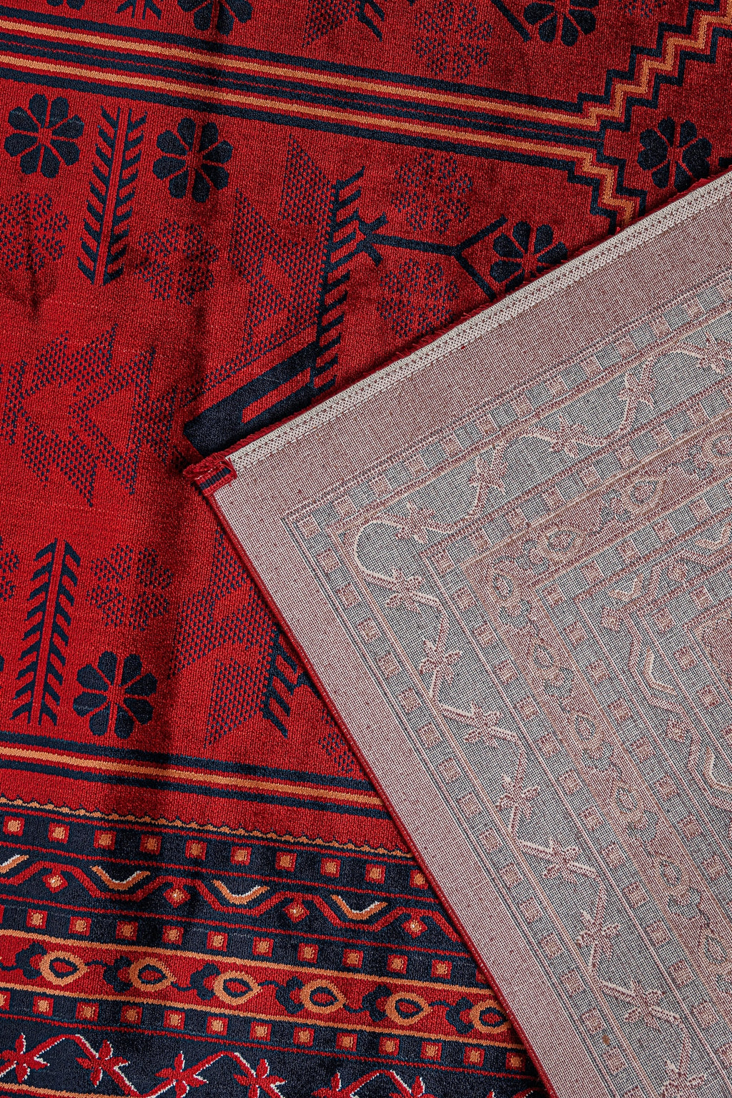 Kırmızı zemin üzerine siyah ve turuncu Afgan halısı motifleri ve halının açık renkli arkası