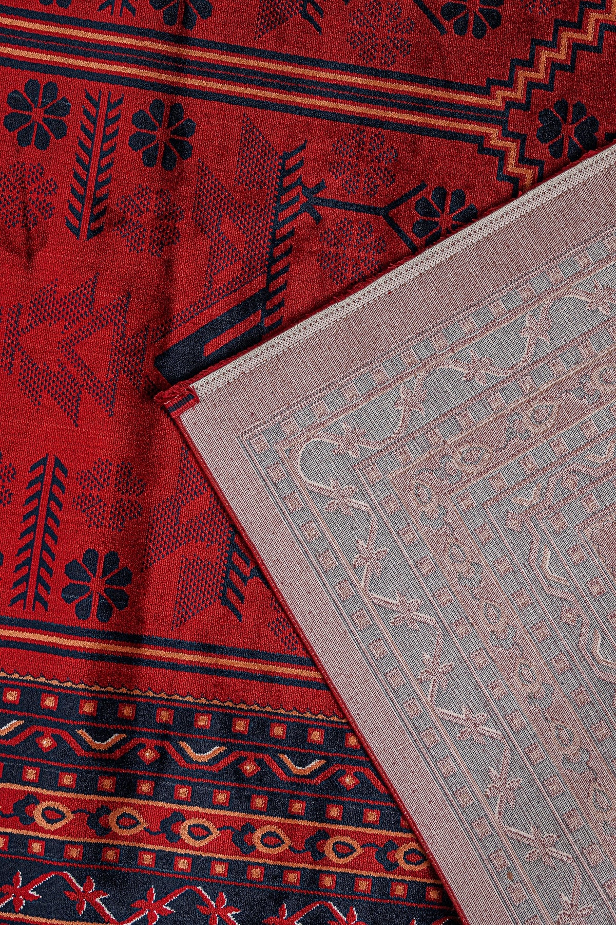 Kırmızı zemin üzerine siyah ve turuncu Afgan halısı motifleri ve halının açık renkli arkası