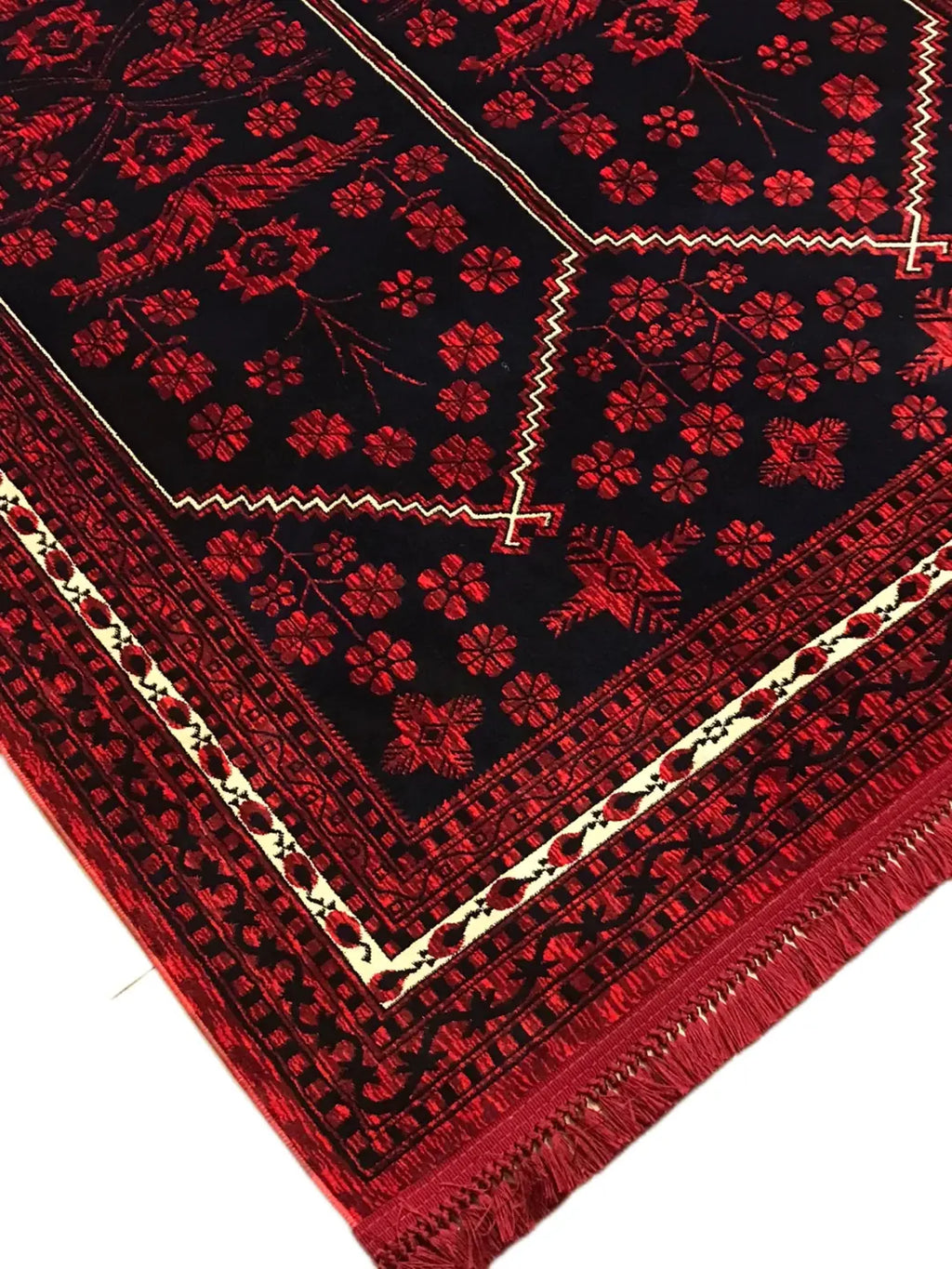 Kırmızı ve siyah renklerde çiçek ve geometrik desenli Afgan halısı, kenarında püsküller