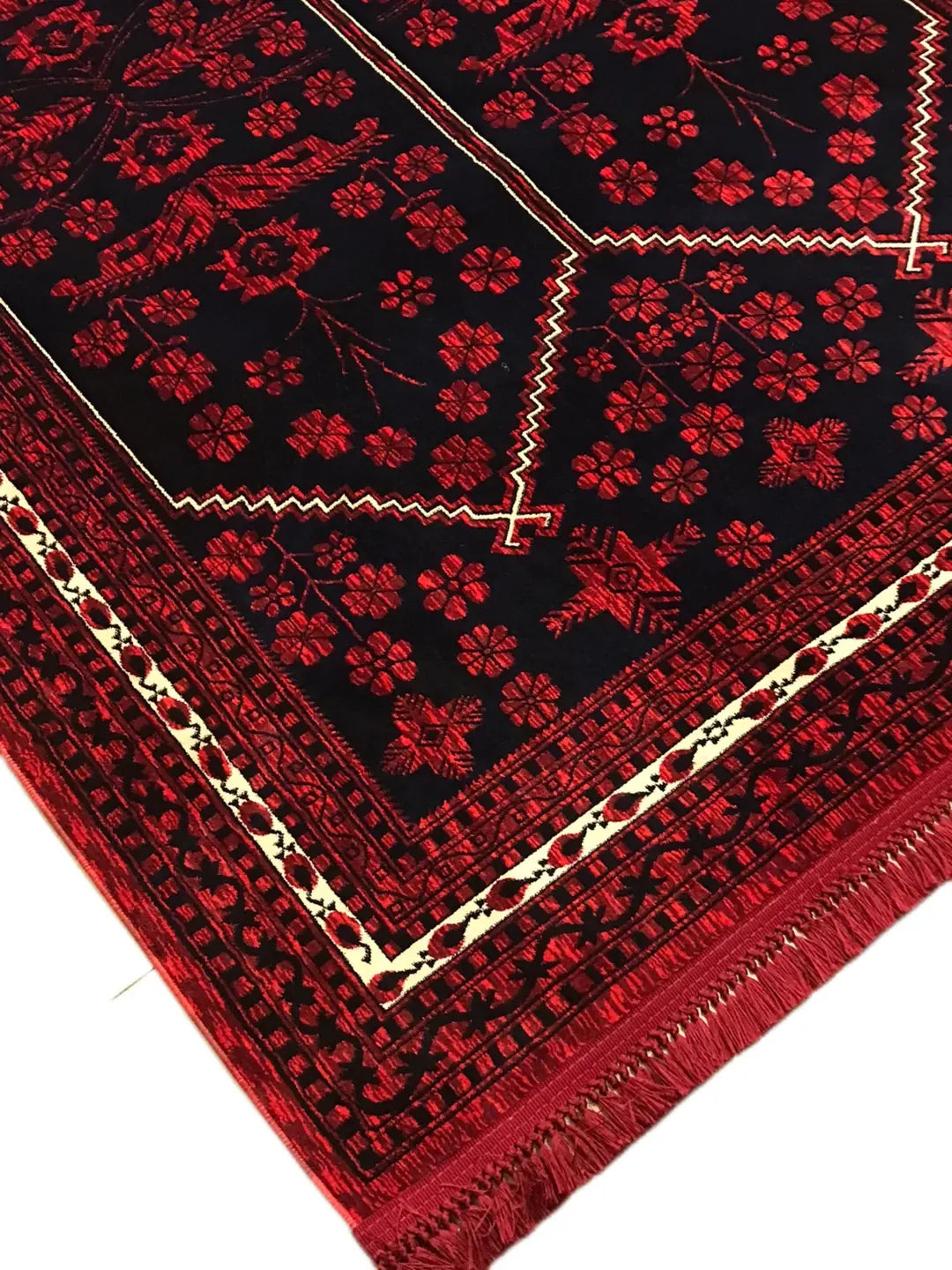 Kırmızı ve siyah renklerde çiçek ve geometrik desenli Afgan halısı, kenarında püsküller