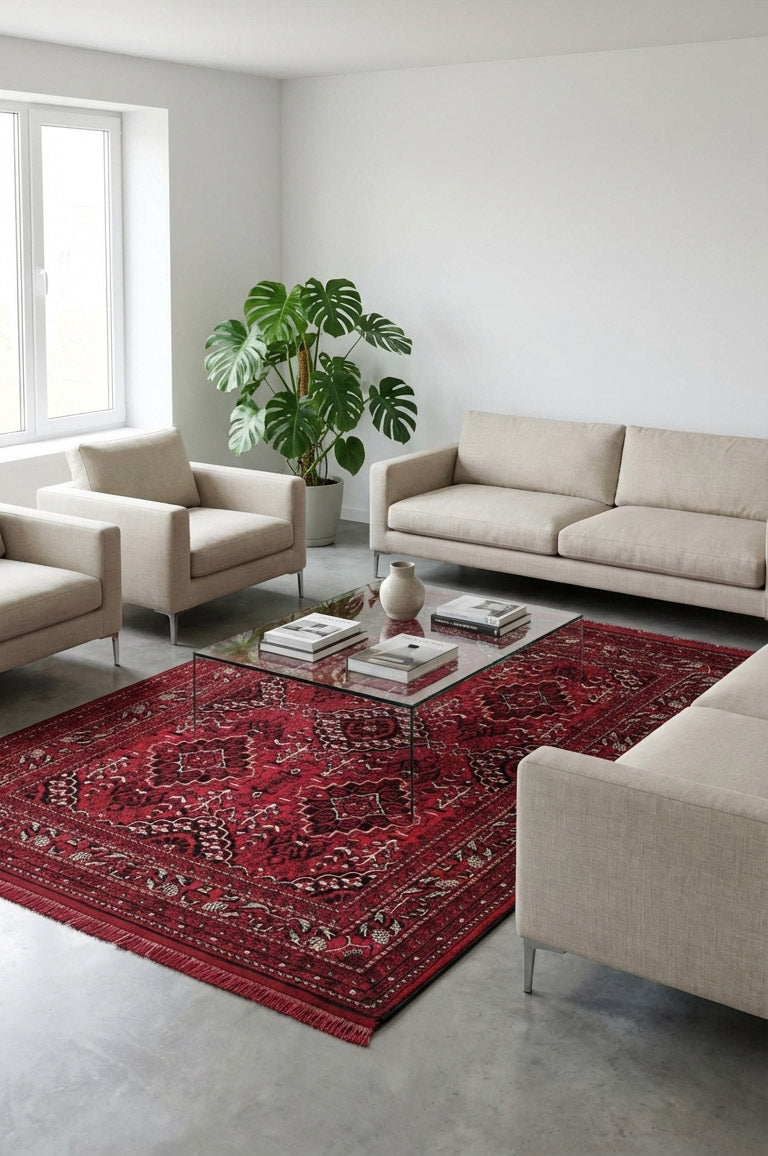 Modern bej koltuklar ve cam sehpa üzerinde kitaplar, kırmızı dekoratif halı, salon bitkisiyle şık oturma odası