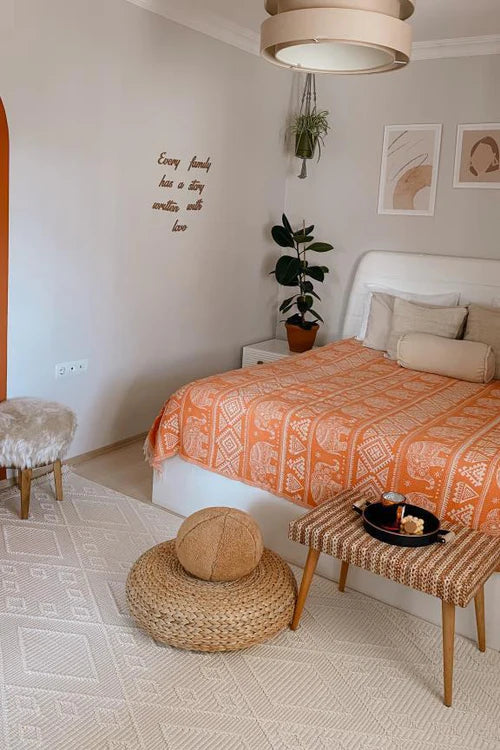Turuncu desenli yatak örtüsü ve bej makine halısı ile modern dekorasyonlu yatak odası