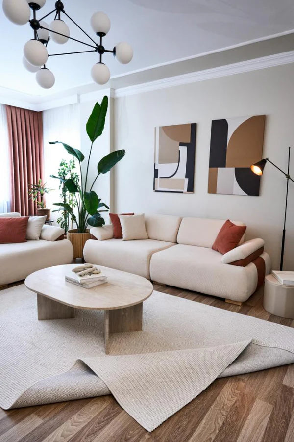 Modern ekru makine halısı, krem koltuklar, ahşap zemin, büyük salon bitkisi ve soyut duvar tabloları