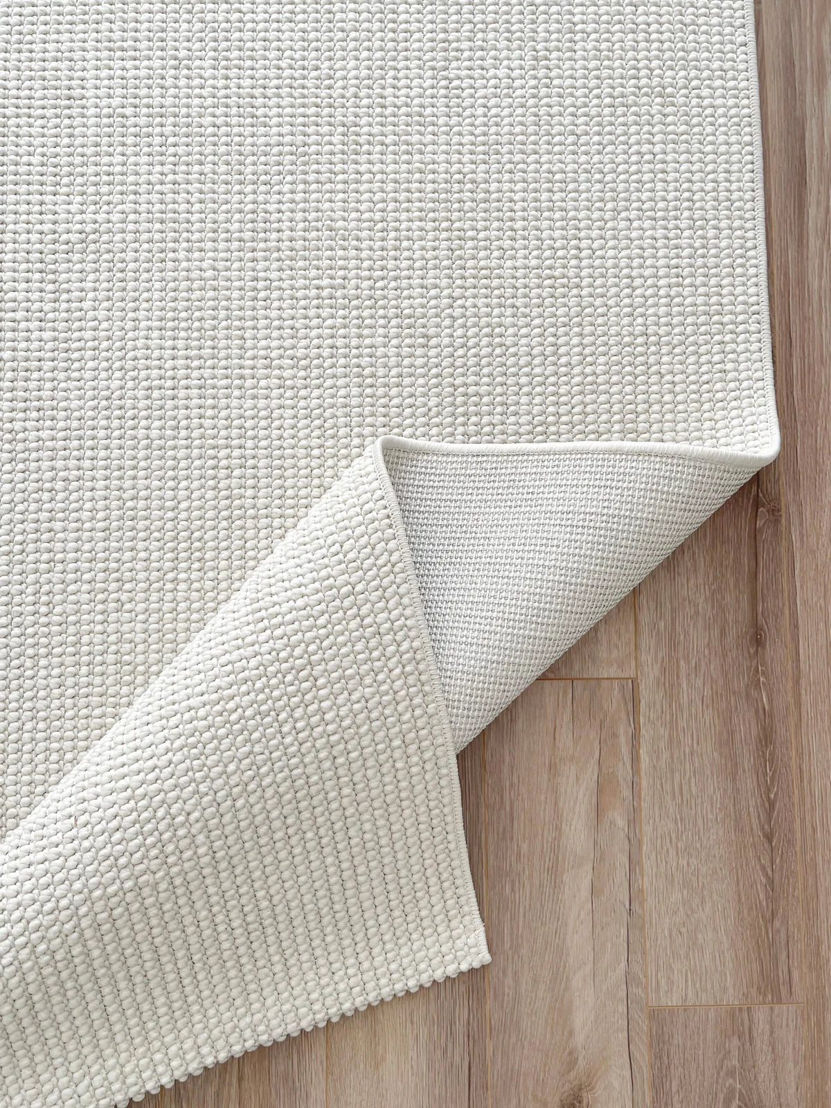 Ekru renkli, dokulu havana 8595 makine halısı, açık ahşap zemin üzerinde