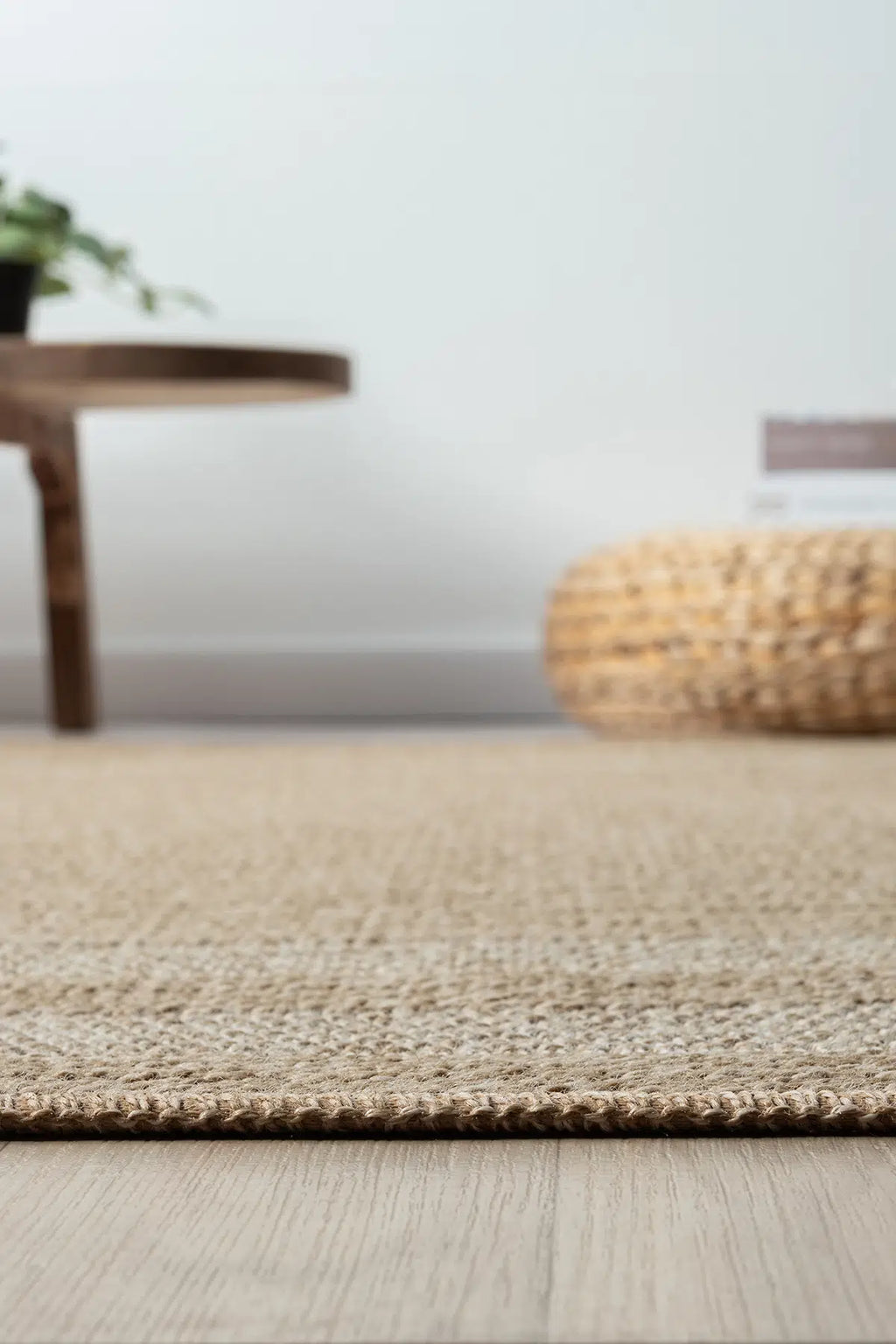 Doğal dokulu açık renk seyran halı, ahşap zemin ve örgü minder ile modern dekorasyon