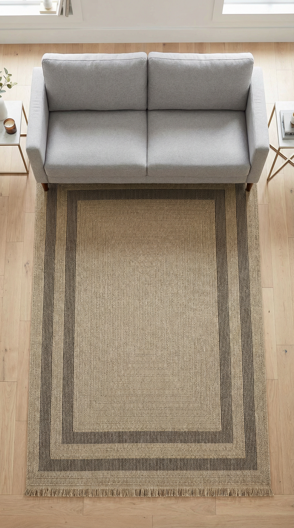 Modern gri kanepe üzerinde, doğal tonlarda siyah çizgili bej jüt kilim, açık ahşap zemin