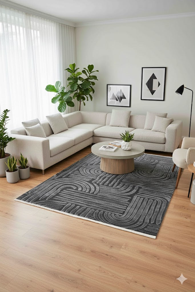 Açık renk köşe kanepe, modern siyah beyaz soyut duvar tabloları ve geometrik desenli gri halı ile aydınlık salon